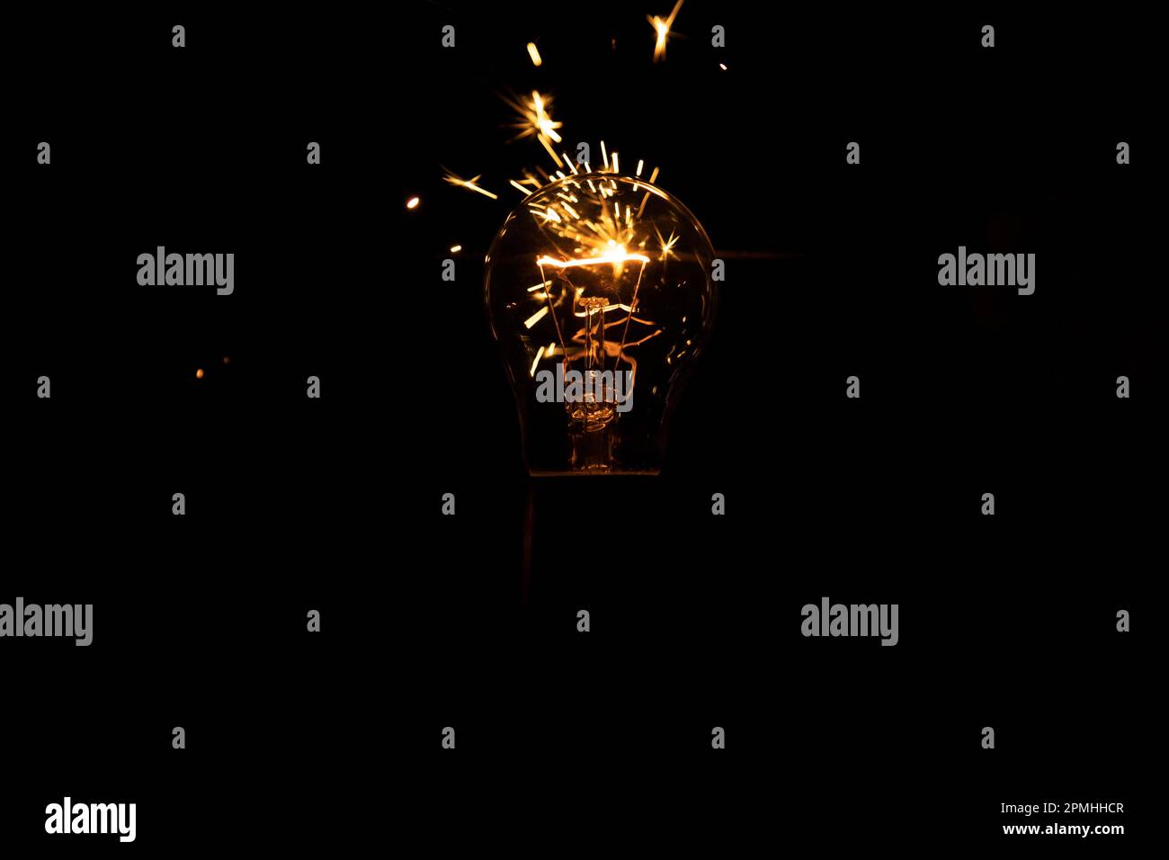 Light and sparks from a burning incandescent lamp. Short circuit. Stock Photo