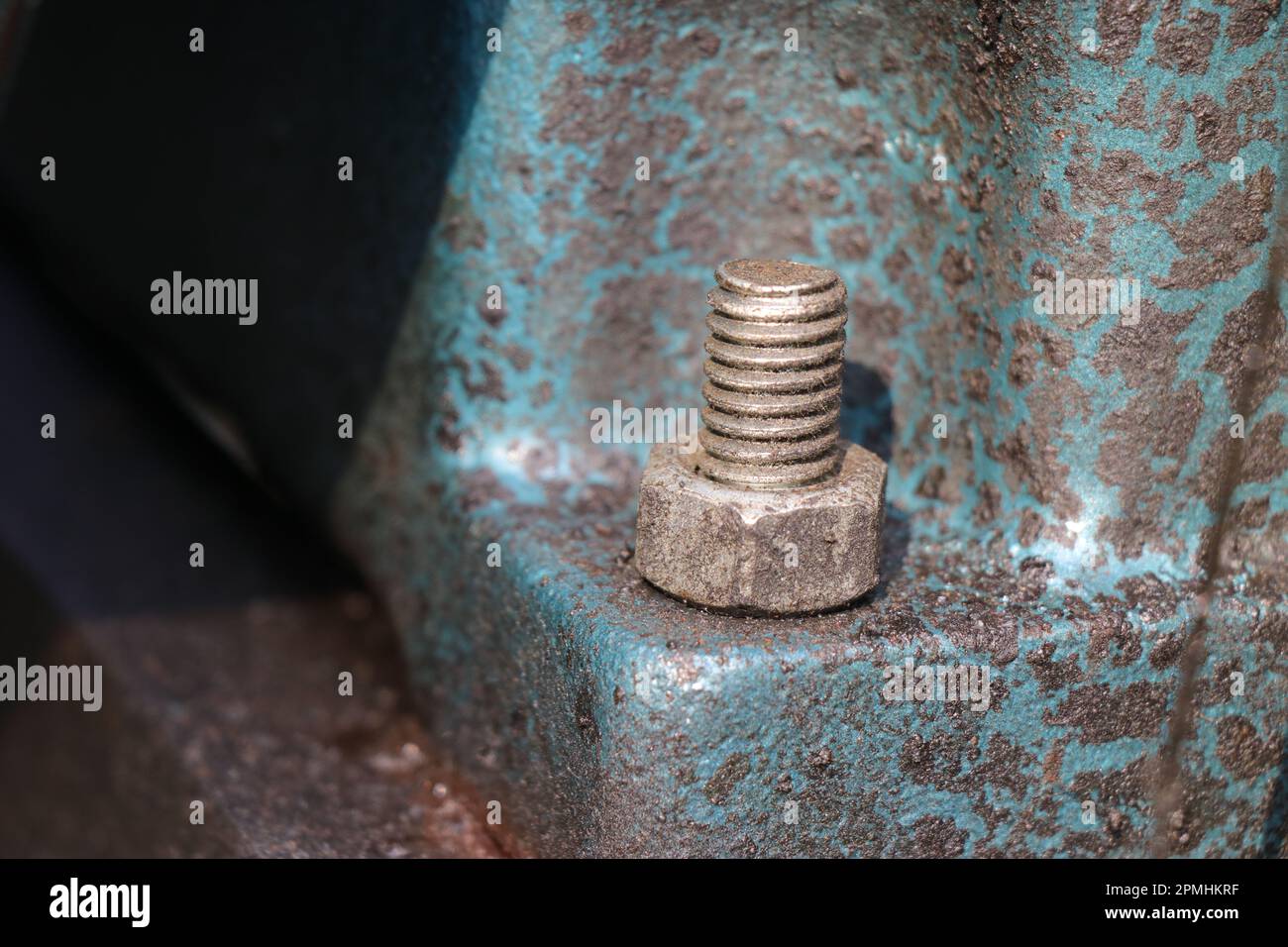 Mild steel nut and bolt are fitted on a cast iron engine block base