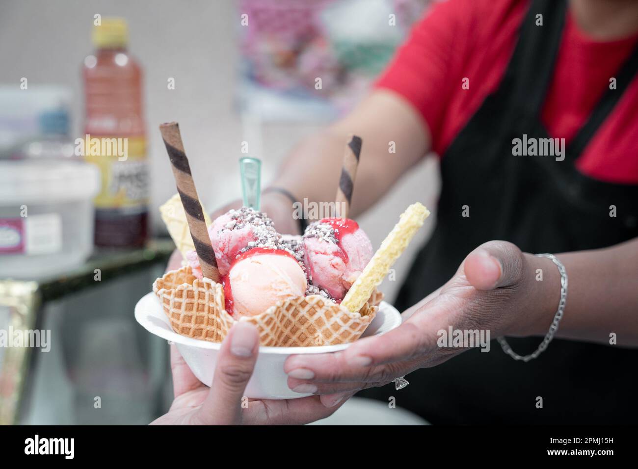 An adult Hispanic woman is serving a traditional Mexican ice cream with