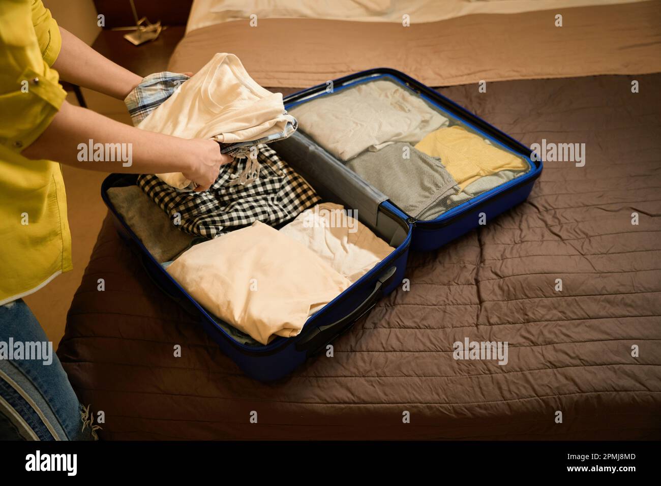 Woman in jeans takes out clothes from a travel suitcase Stock Photo Alamy