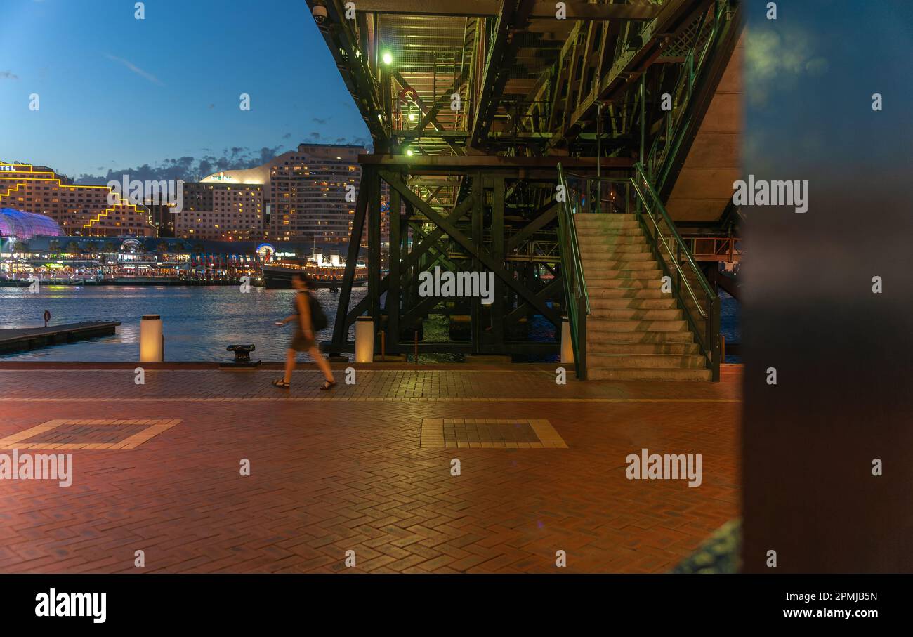 Sydney Australia - January 25 2011; Night on street, view from under Pyrmont Bridge with woman blurred in motion Stock Photo