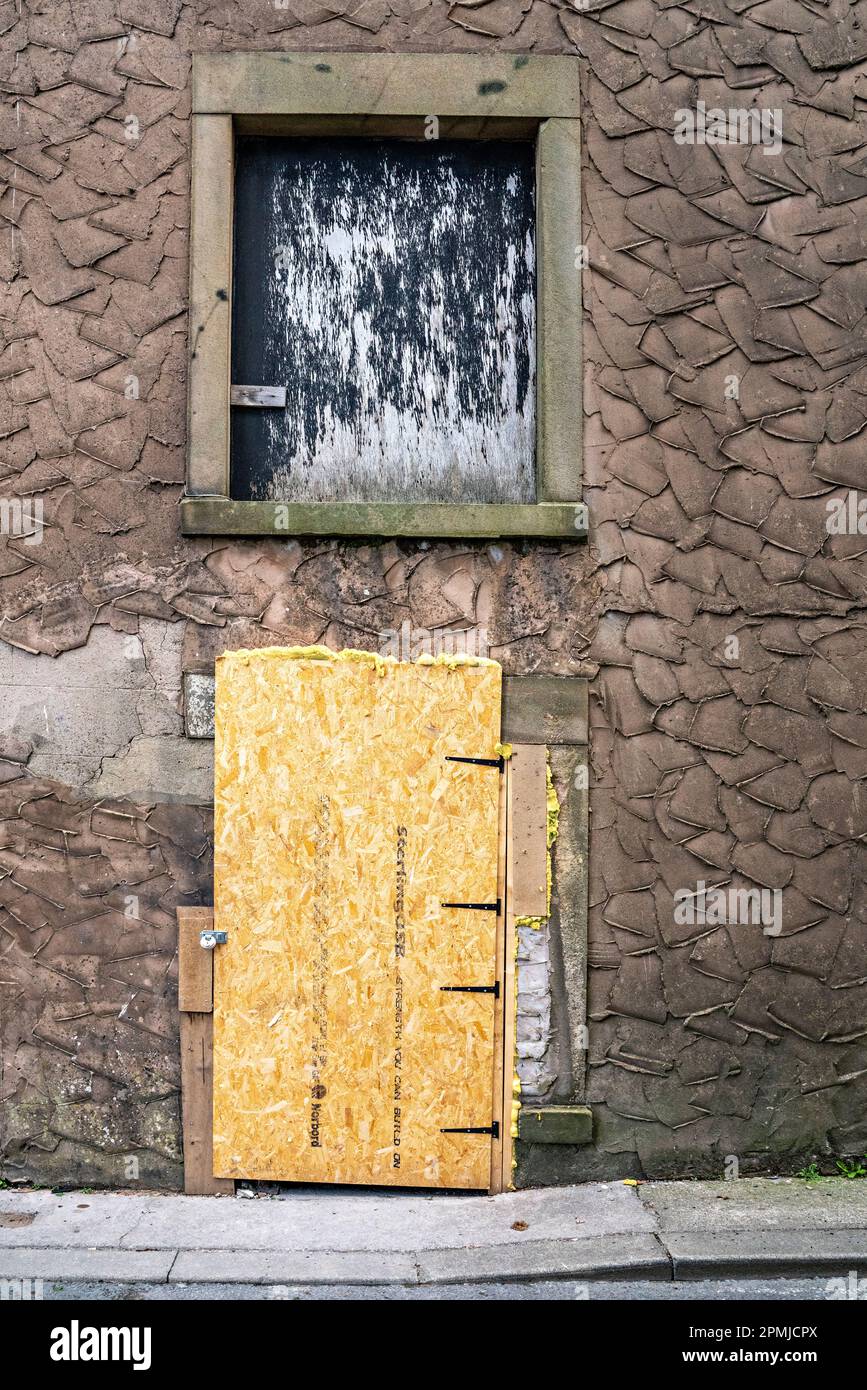 Boarded up door and window of commercial building Stock Photo