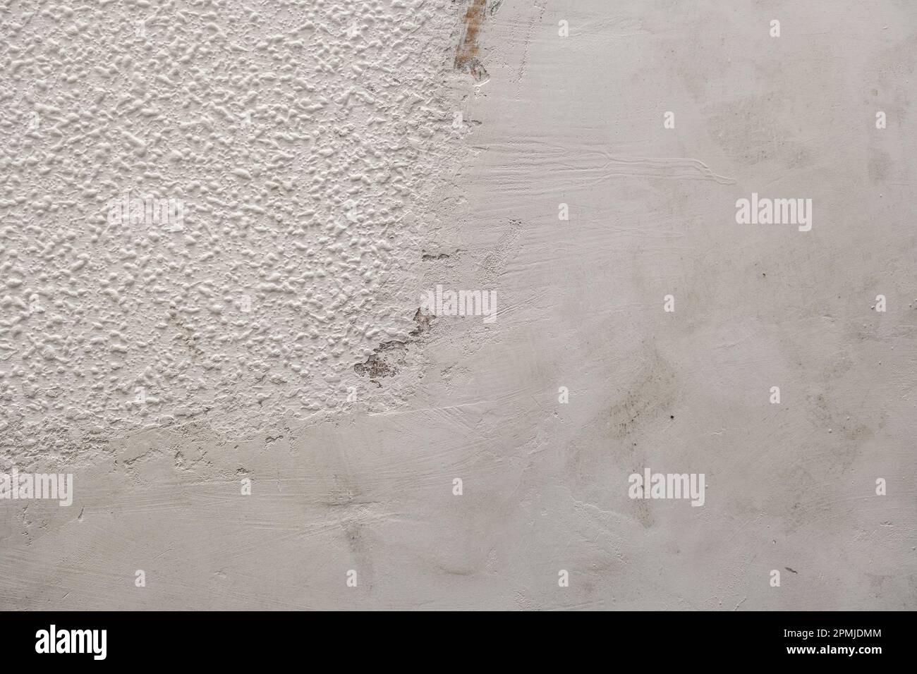 Detail of cement render plaster coating on old popcorn ceiling wall