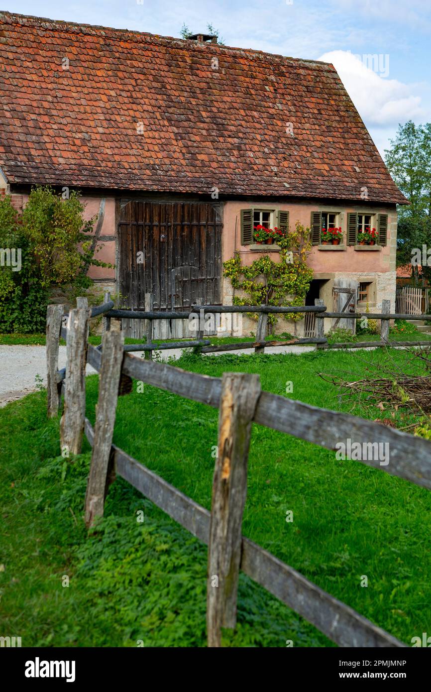 Very old abandoned farm house with wooden fence Stock Photo