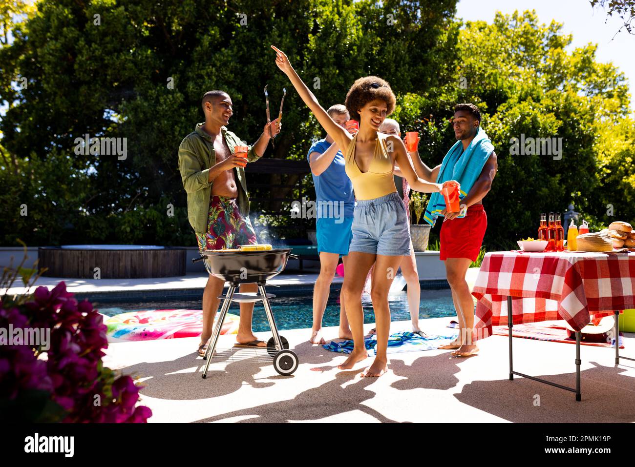 Happy diverse group of friends having pool party, barbecuing and ...