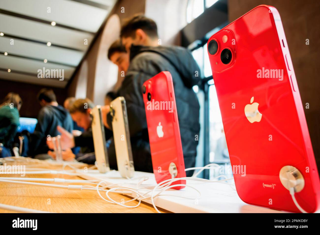 Paris, France - Sep 16, 2022: Row of red phones as People testing new Apple Computers iPhone 14, 14 Pro, Pro Max on sale during the launch day featuring Always-on display, 48-megapixel Main camera and Dynamic Island Stock Photo