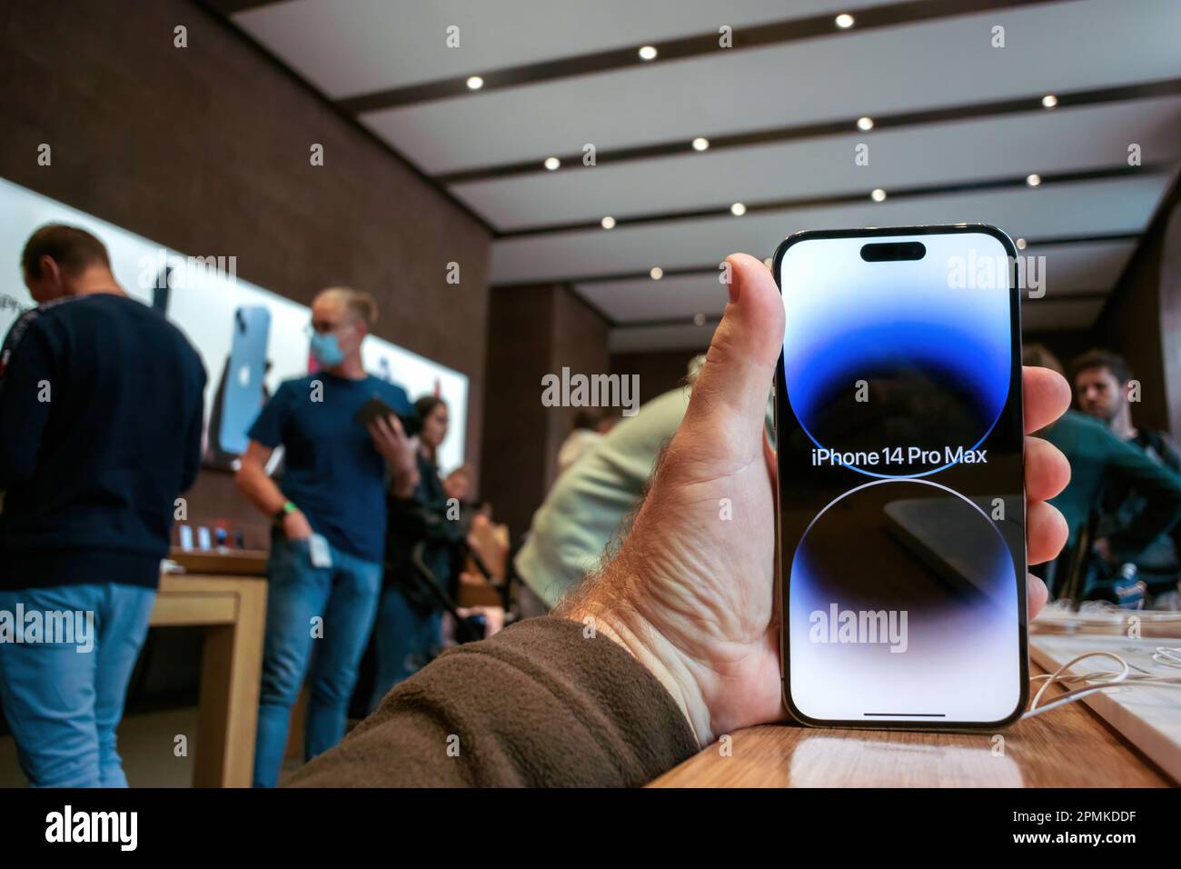 Paris, France - Sep 22, 2022: Customer inside apple store admiring new smartphone Max with all apps on home screen - Apple launch new smartphone iPhone 14 Pro and iPhone 14 Pro Max - woman comparing phone nearby Stock Photo