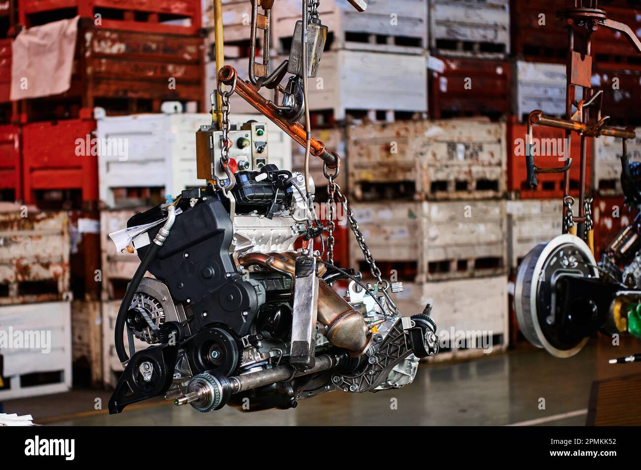 Powerful car motor hangs on chains in assembling Stock Photo