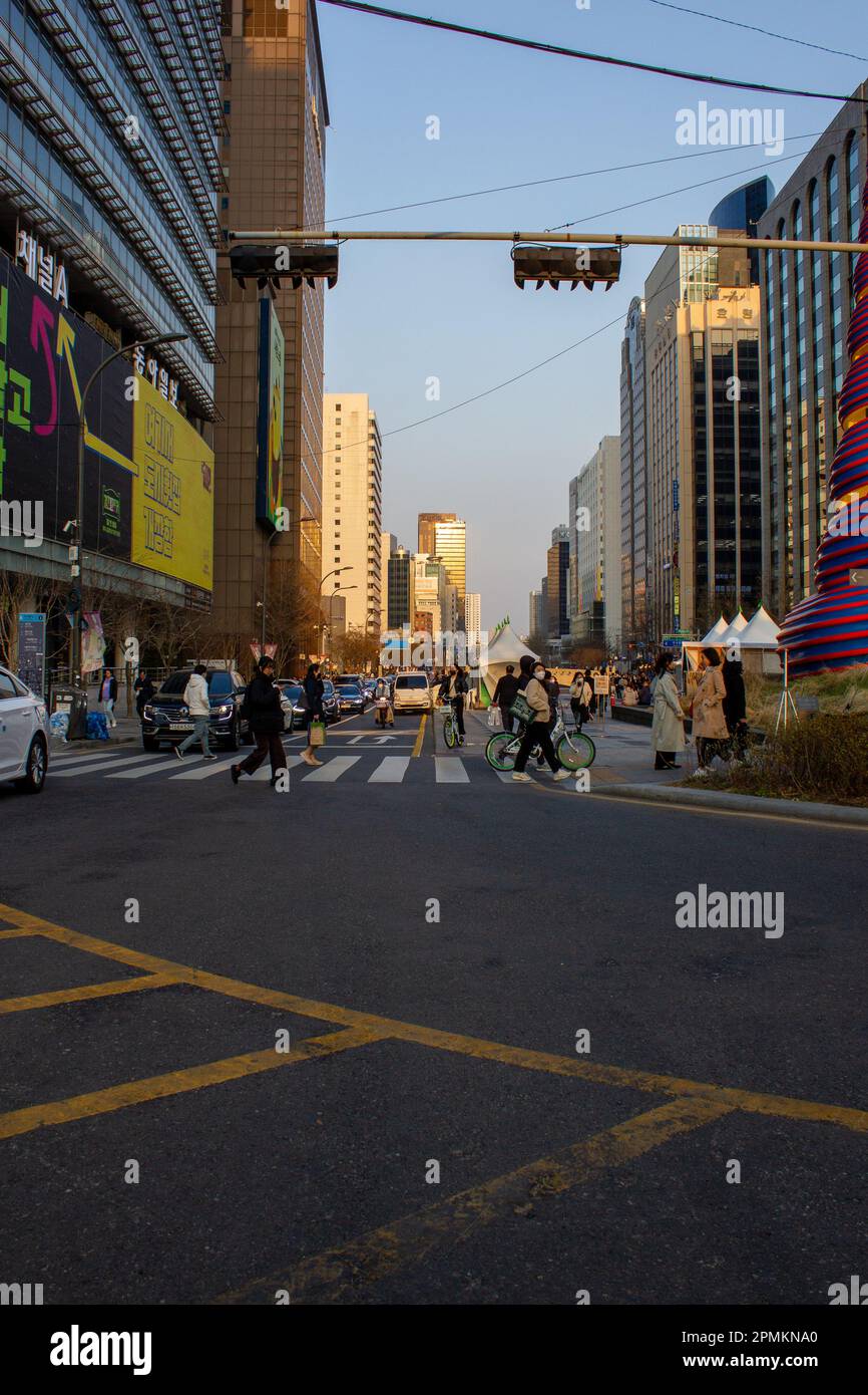 Street photography in the metropolis of Seoul, South Korea. Appreciating the sunset illuminating the streets and the people walking along those street. Stock Photo