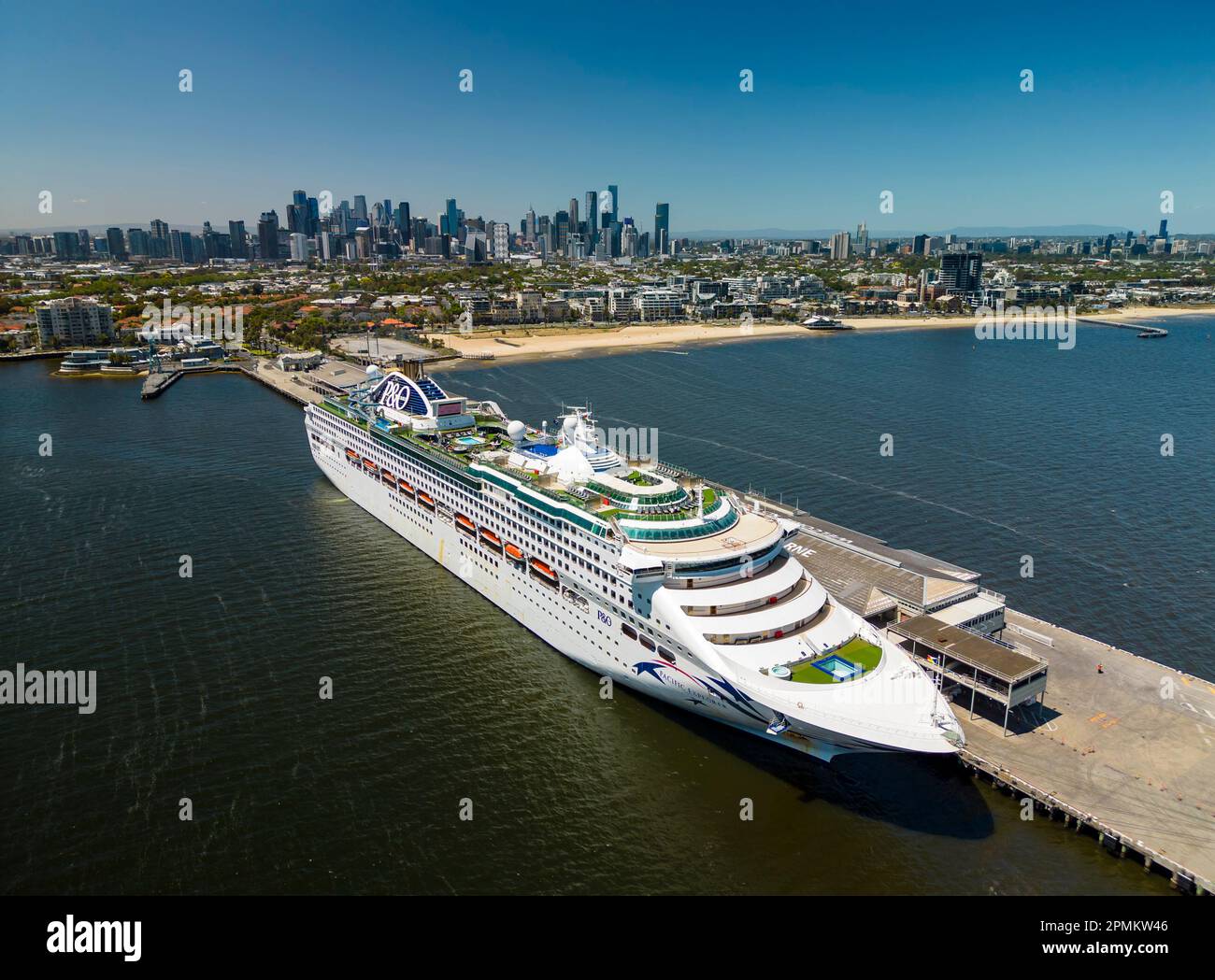 Melbourne, Australia - Dec 19, 2022: Aerial shot of cruise ship in Port Melbourne with city skyline in the background Stock Photo