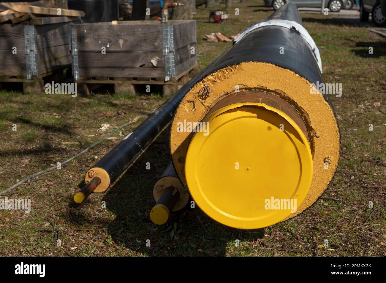 the yellow end of a district heating pipe lying on the ground at a construction site in Frederikssund, Denmark, April 13, 2023 Stock Photo