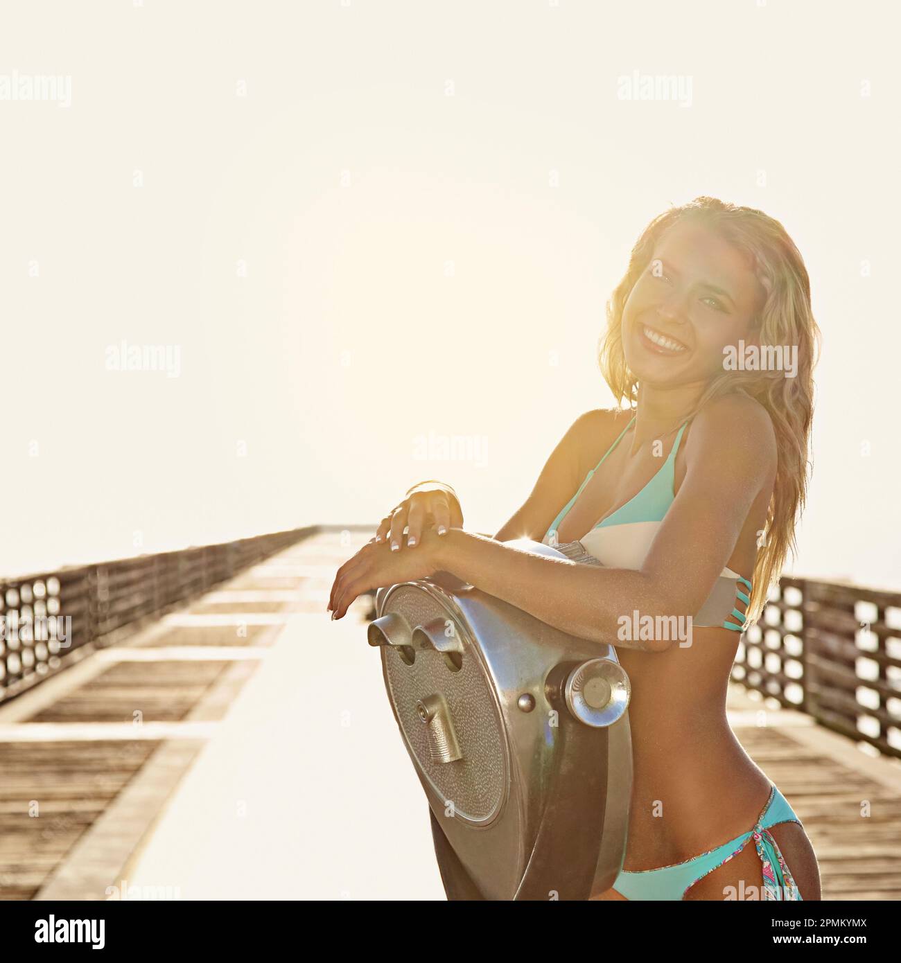 Live in the sunshine. a young woman standing by a binocular. Stock Photo