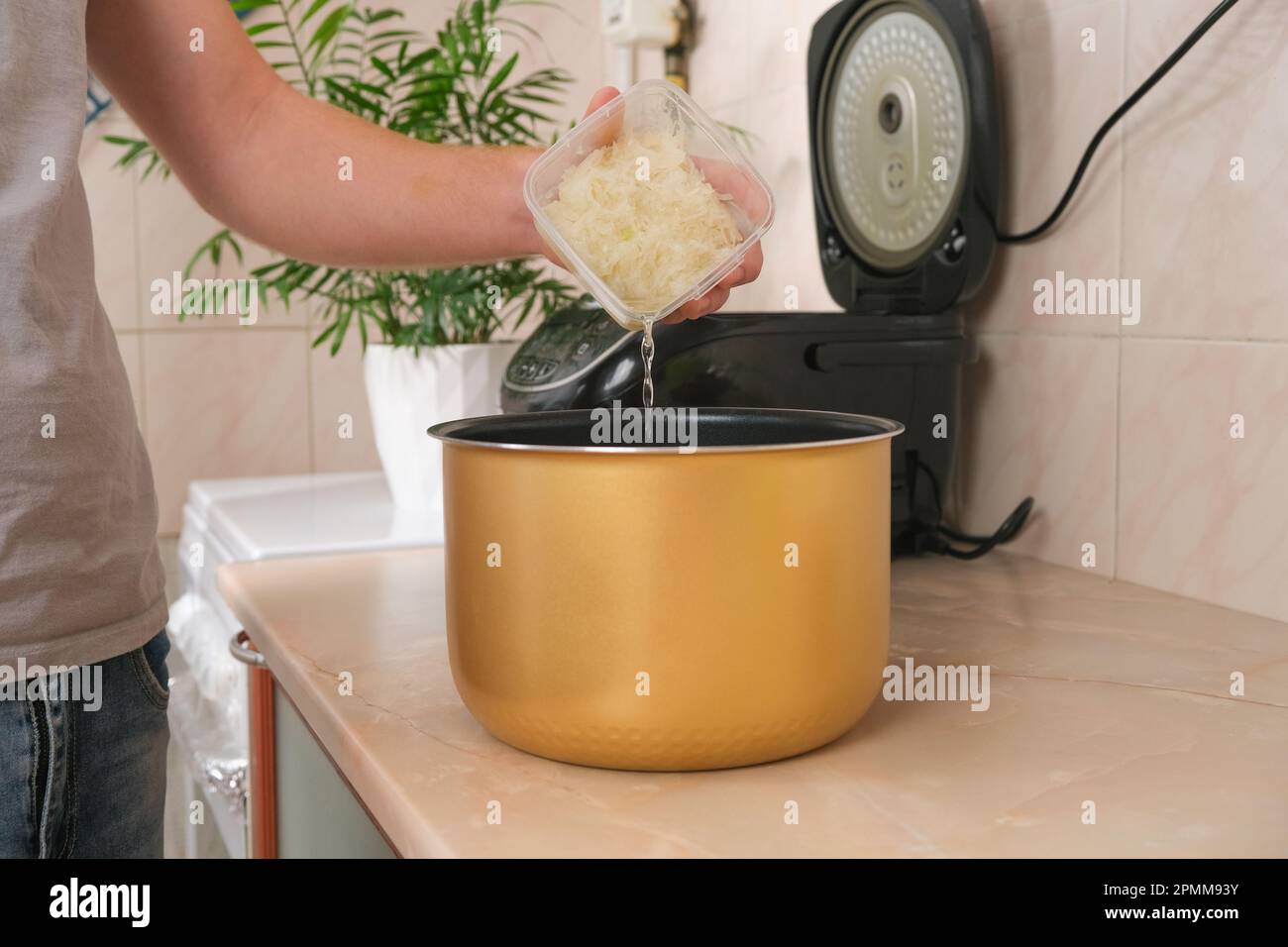 The man puts the frozen grated onion with juice into bowl of slow