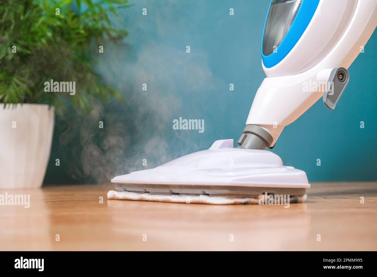 A man washes the floors with a steam mop. Floor treatment with hot