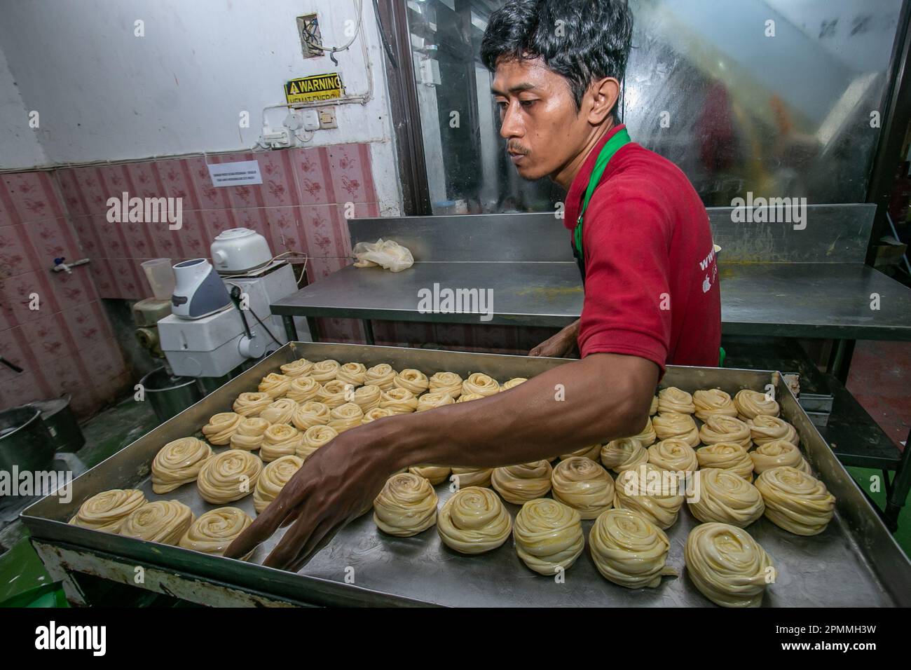 A worker produces cane bread at a Middle Eastern frozen food home