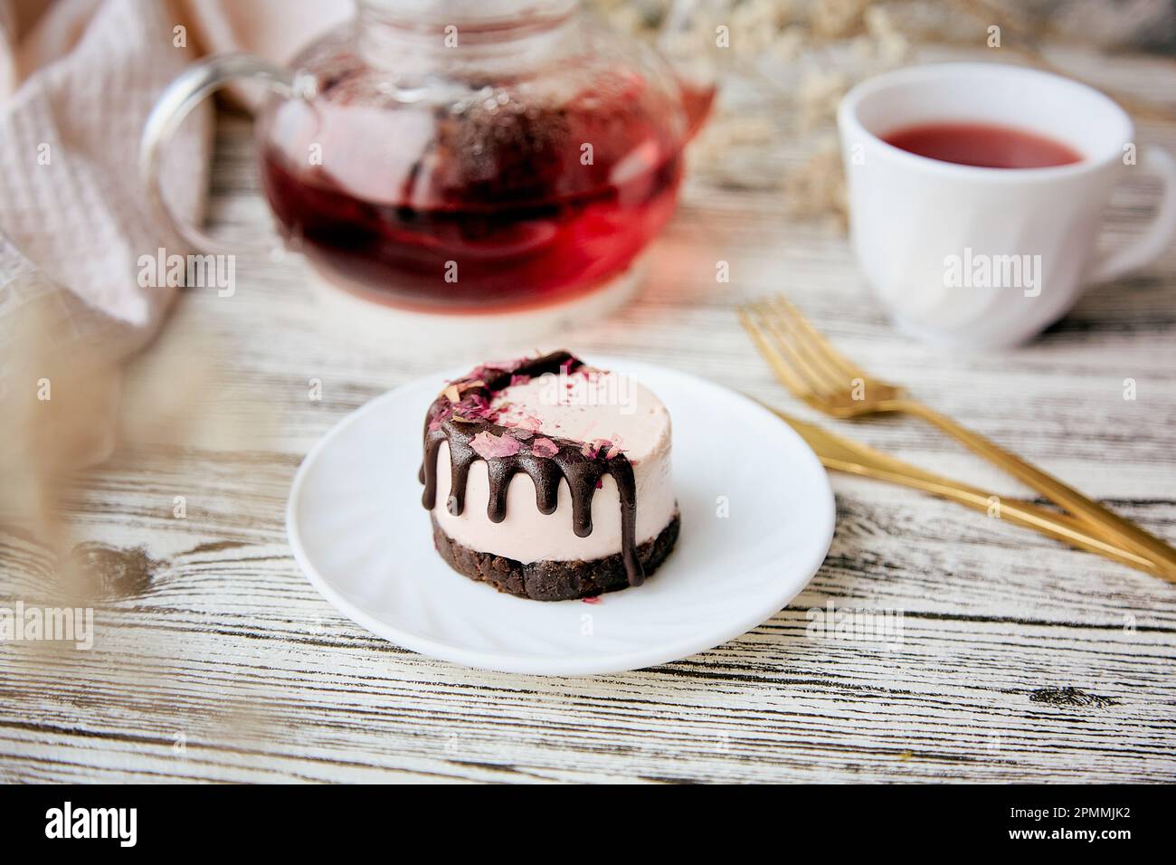 No sugar raspberry vegan dessert with carob and teapot and cup of natural tea. Healthy breakfast. Stock Photo