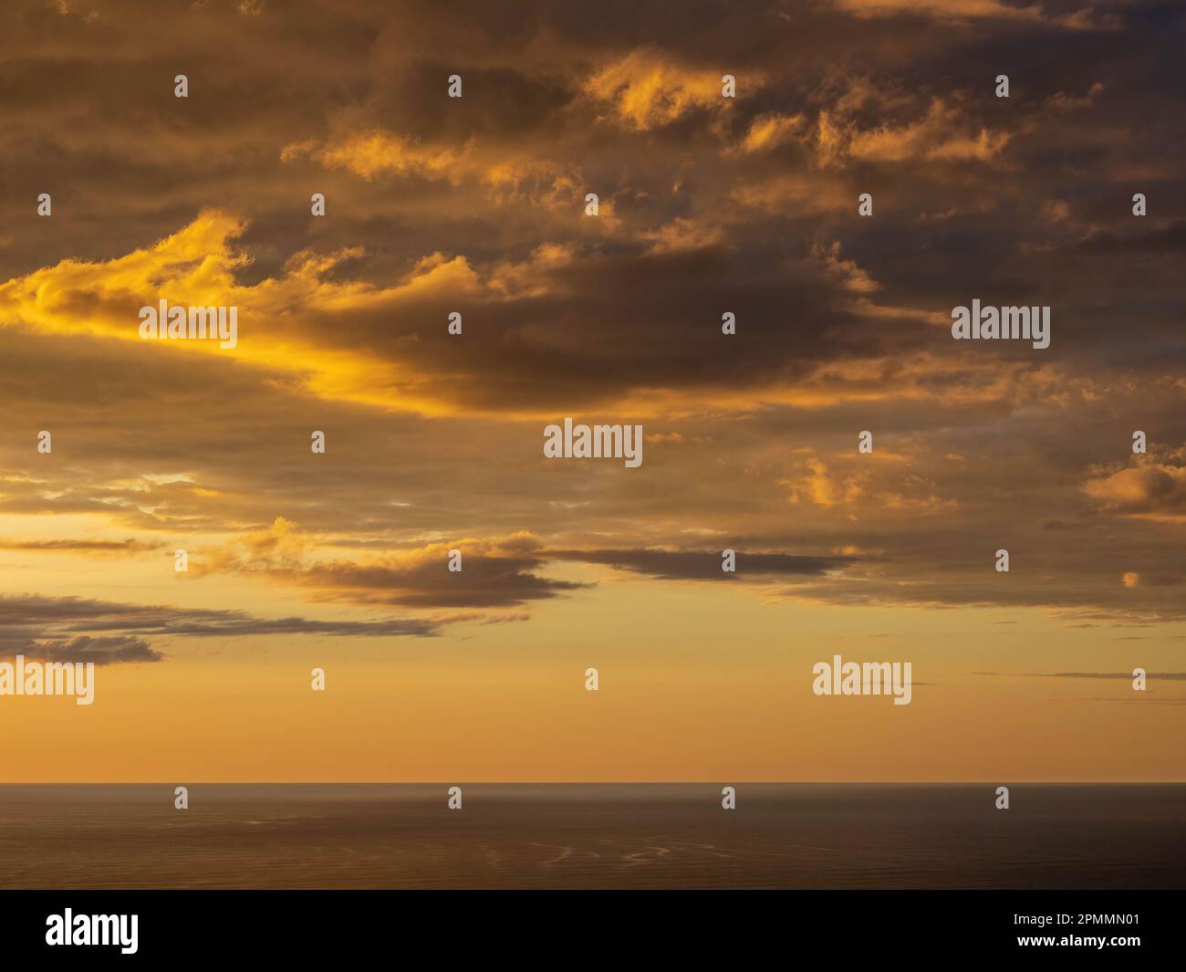 A beautiful sunset over the horizon of the ocean, with clouds ...
