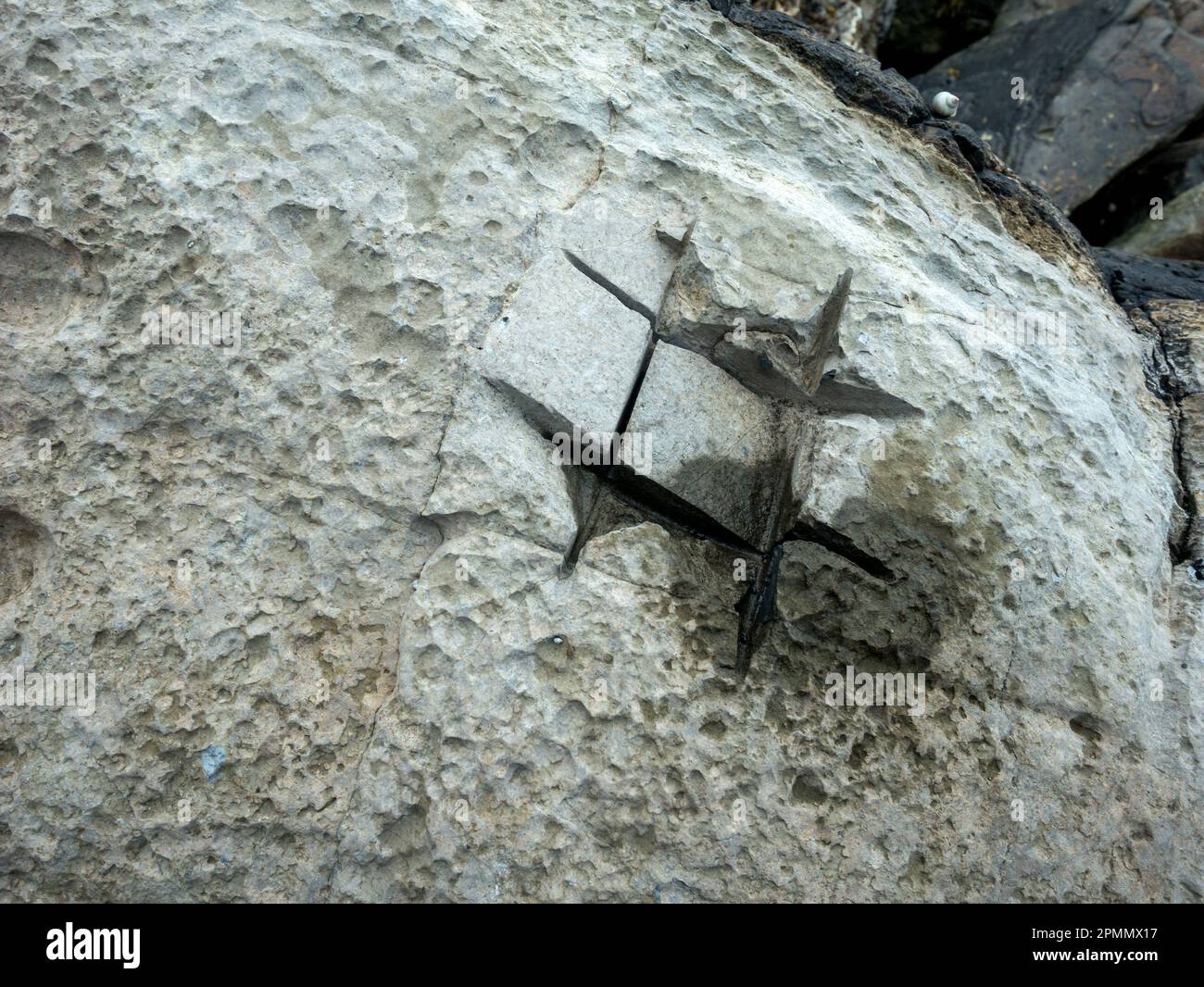 Crude rock 'core' sampling using angle grinder slit cuts into boulder on Elgol beach, Isle of Skye, Scotland, UK Stock Photo