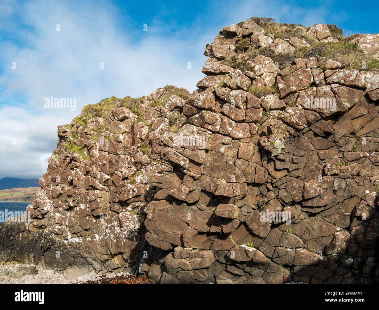 A rock wall formed by the exposed face of a basalt igneous intrusion Paleogene dyke, Tokavaig, Sleat, Isle of Skye, Scotland. Stock Photo