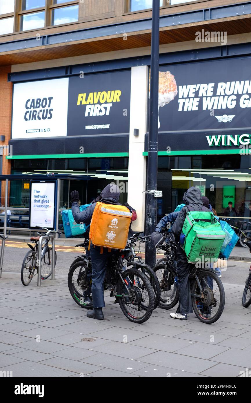 Food delivery riders working for Just Eat, Uber Eats, Deliveroo chatting while waiting for orders. Brisol, UK Stock Photo