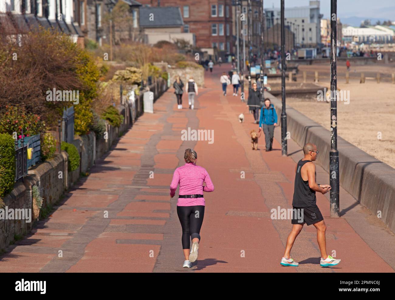Portobello, Edinburgh, Scotland, UK. 14th April 2023. Morning exercise by the Firth of Forth. Pictured: Peole walking a exercising on the promenade by the Firth of Forth,, temperature 10 degrees centigrade. Credit: Scottishcreative/alamy live news. Stock Photo
