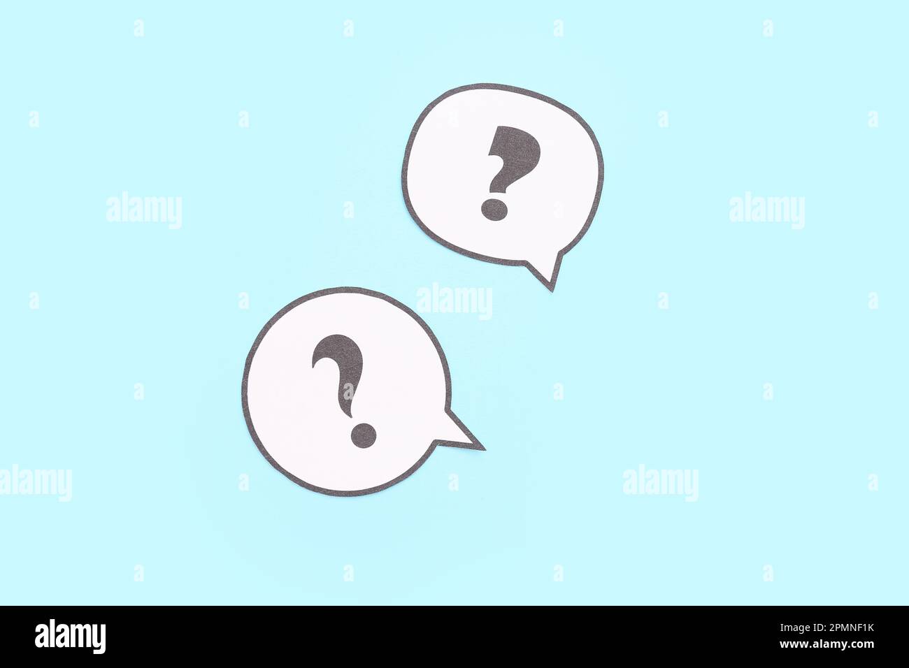 Speech bubbles with question marks on blue background Stock Photo