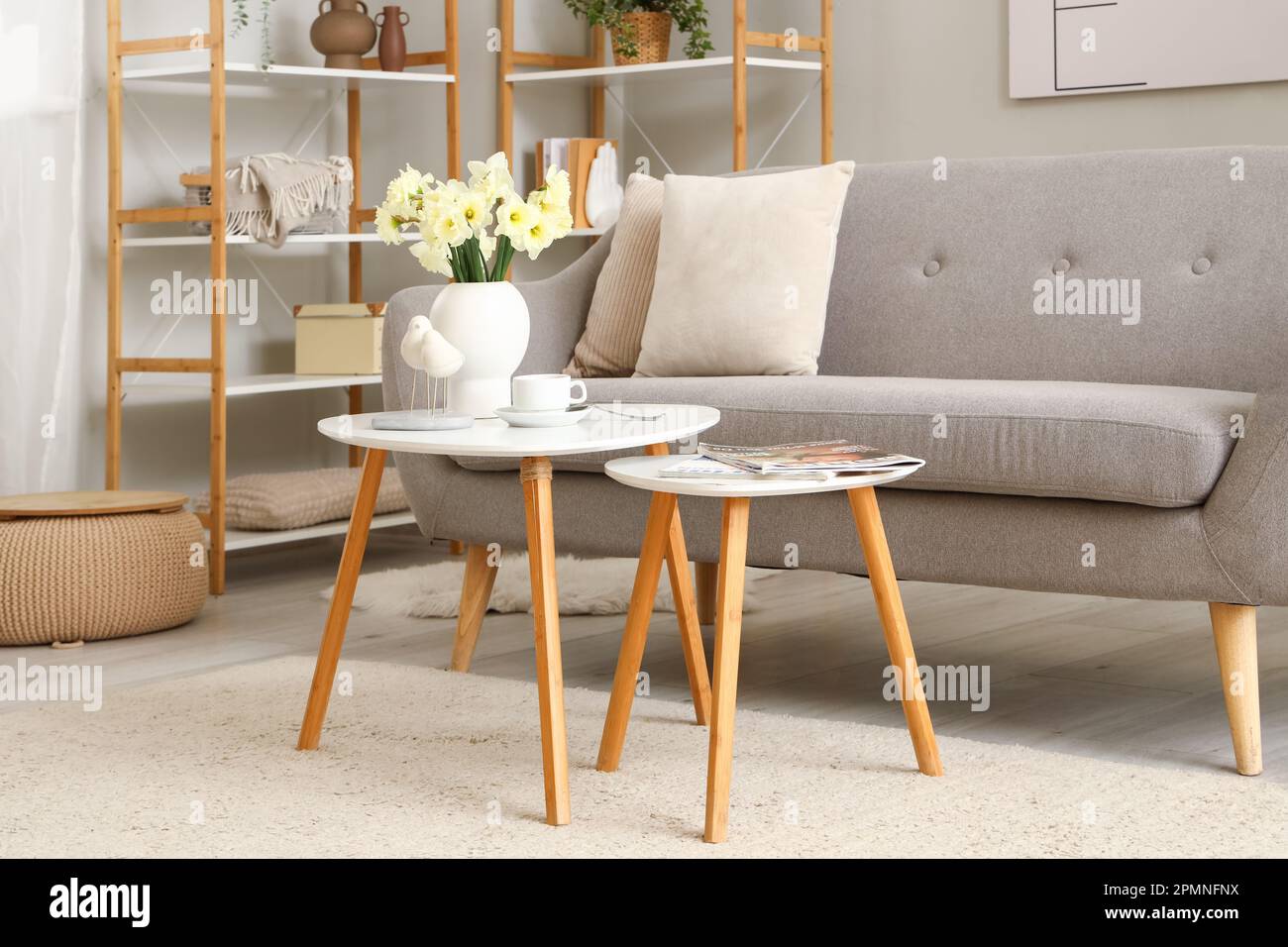 Interior of living room with grey sofa and tables Stock Photo - Alamy