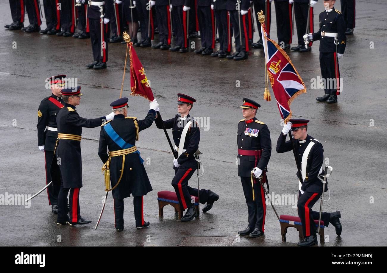 King Charles III touches the new colours of Royal Military Academy