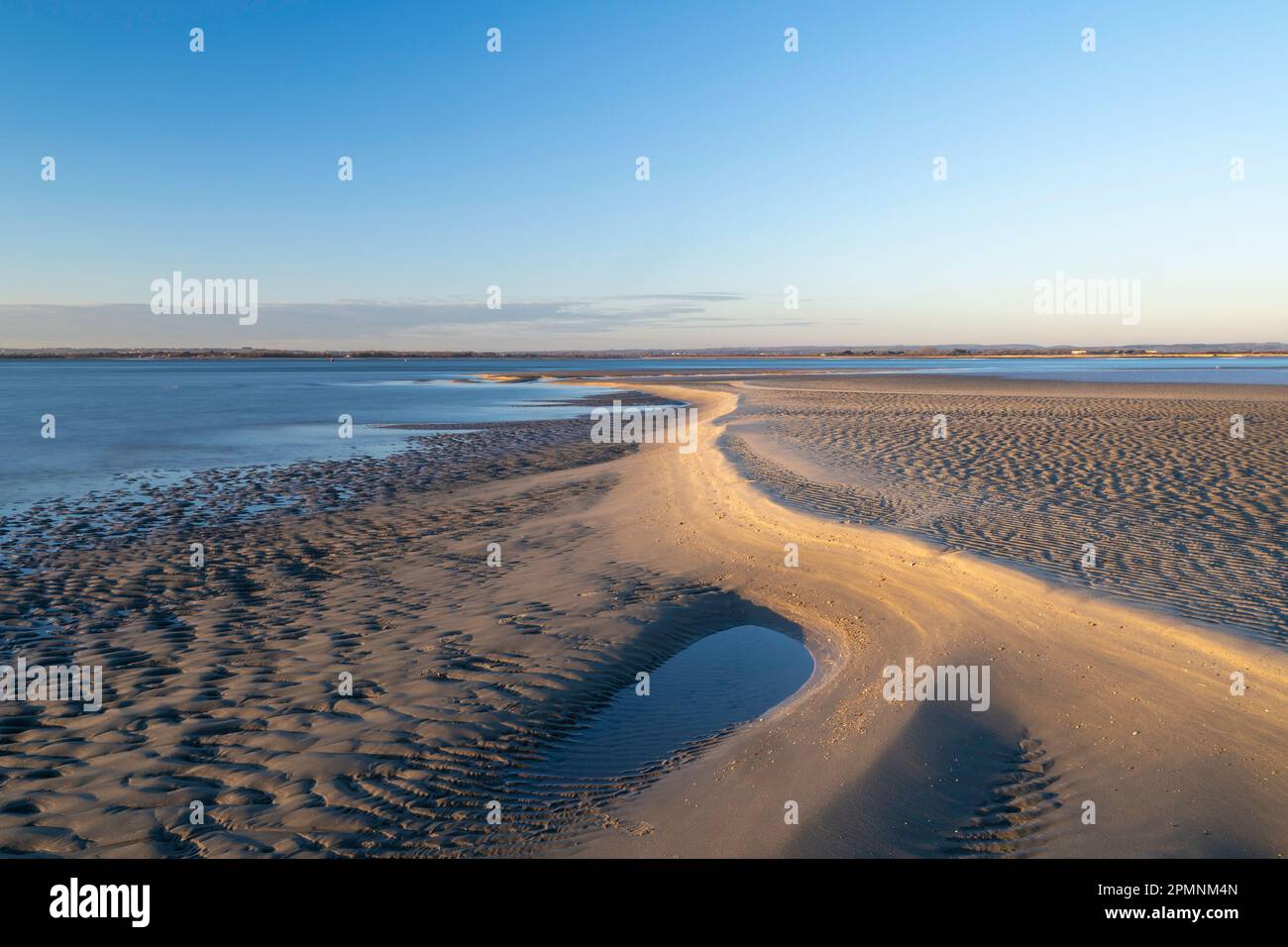 Sculptured Golden sand reflecting the sinking sun at low tide on West Wittering beach Stock