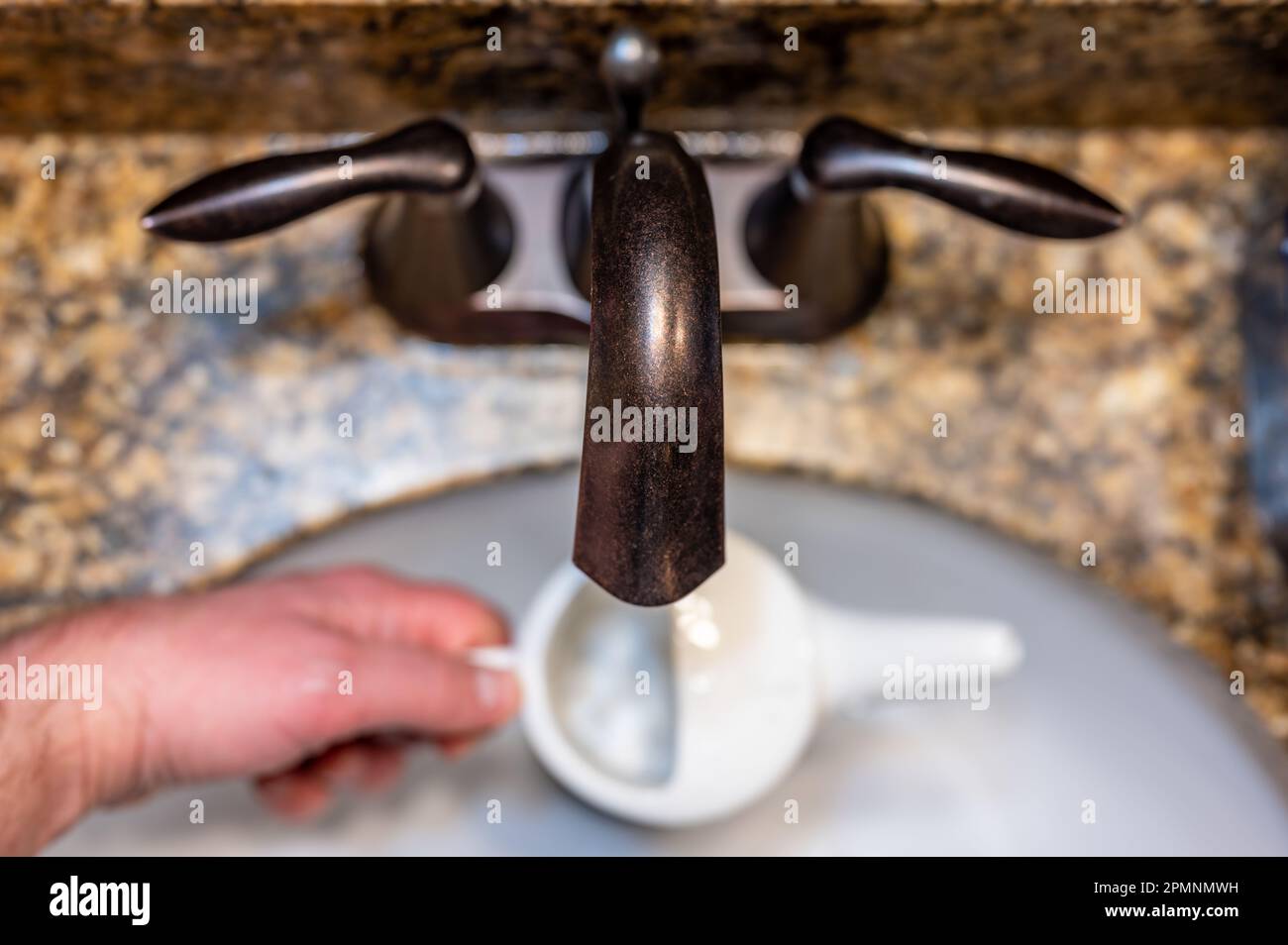 Top view of using a sink to Improperly fill a neti pot with nonsterile