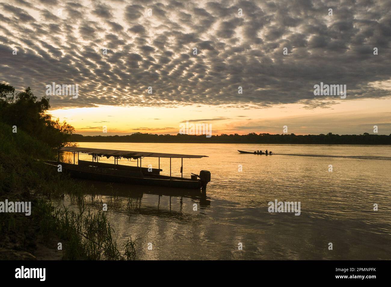 Sunset over Amazon river with boat  cloud and forest background at Puerto Maldonado Peru. Open space area. Stock Photo