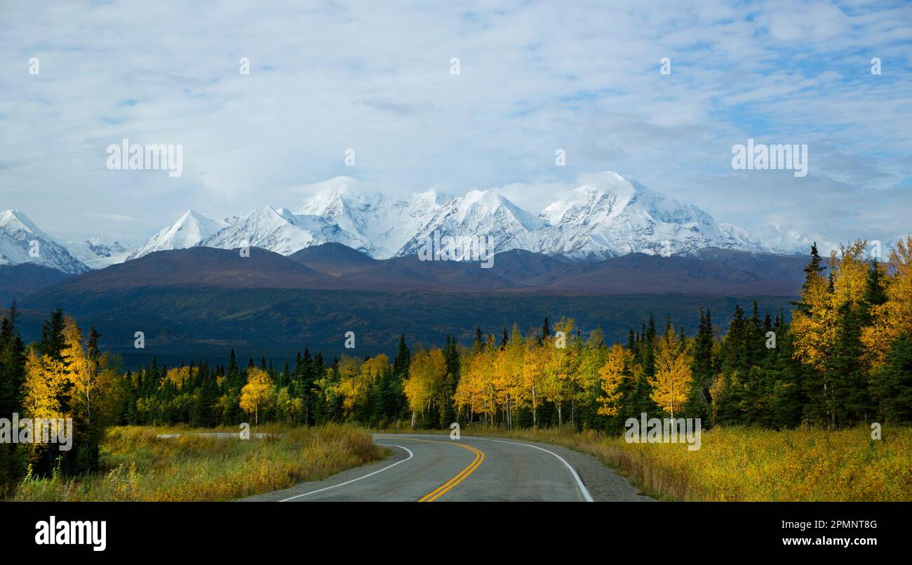 A twisting highway reveals a stunning autumn view of the Rainbow Ridge Mountains; Alaska, United States of America Stock Photo