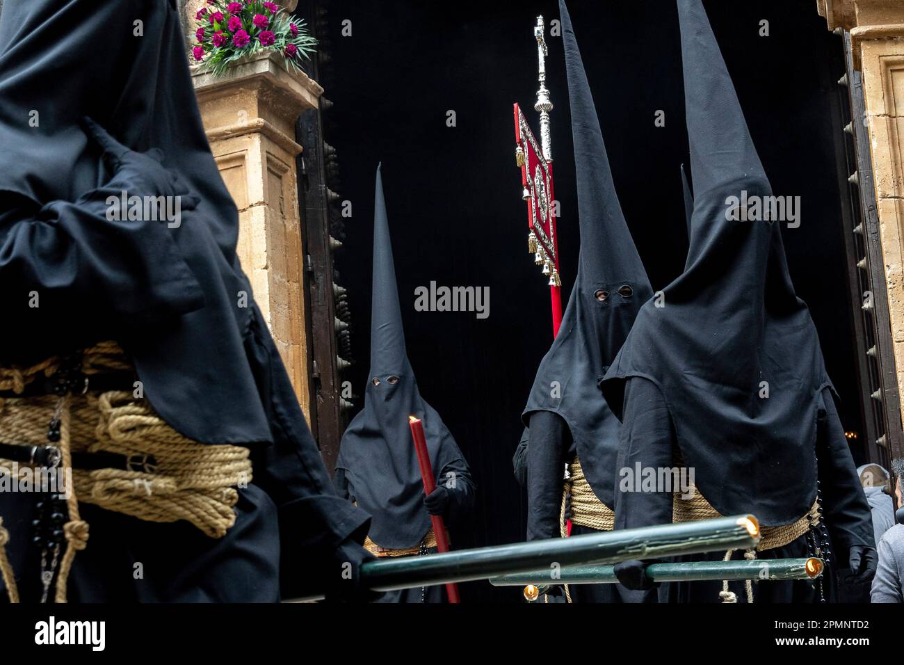 Penitents wearing black cone shaped hoods depart from the St. Mary