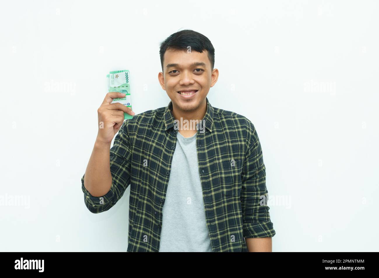 Young Asian man showing Indonesian Rupiah bank note money Stock Photo