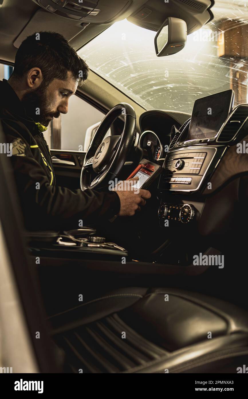 Milan, Italy 11 april 2023: A mechanic's hands use a diagnostic tool to ...