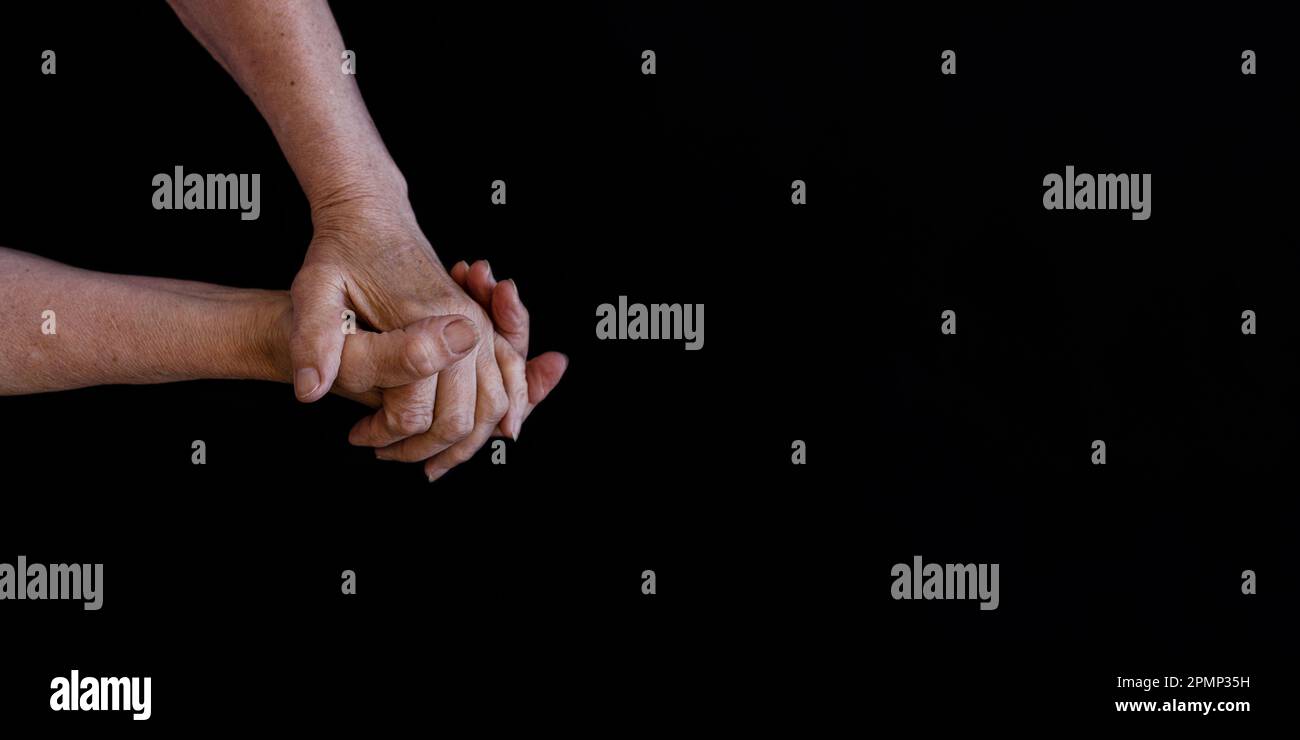palms of old man on a black background. Stock Photo