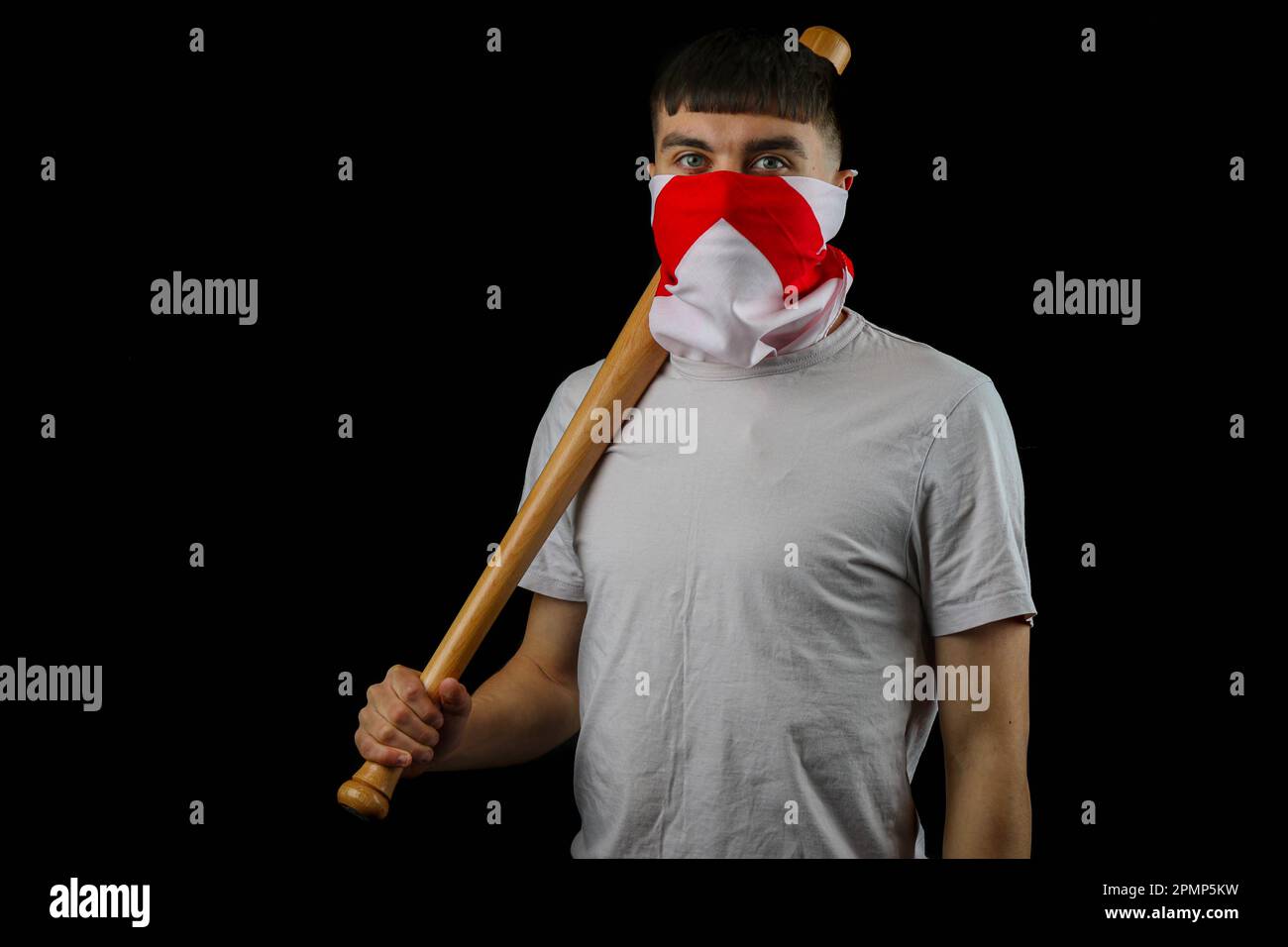 A teenage boy wearing an England flag carrying a baseball bat against a