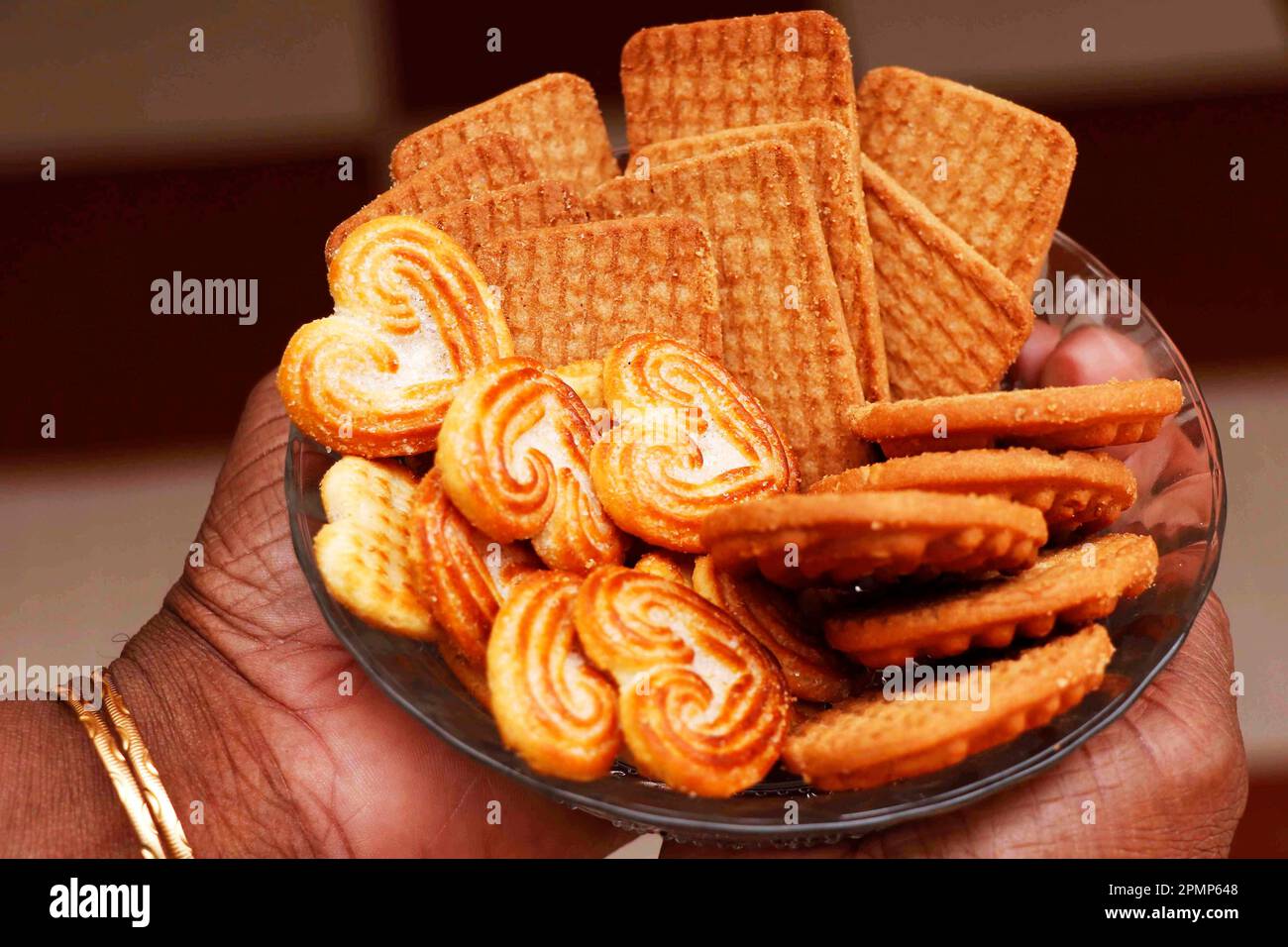 Wheat biscuits in the plate holding q woman. Indian biscuits popularly known as Chaibiscuit in