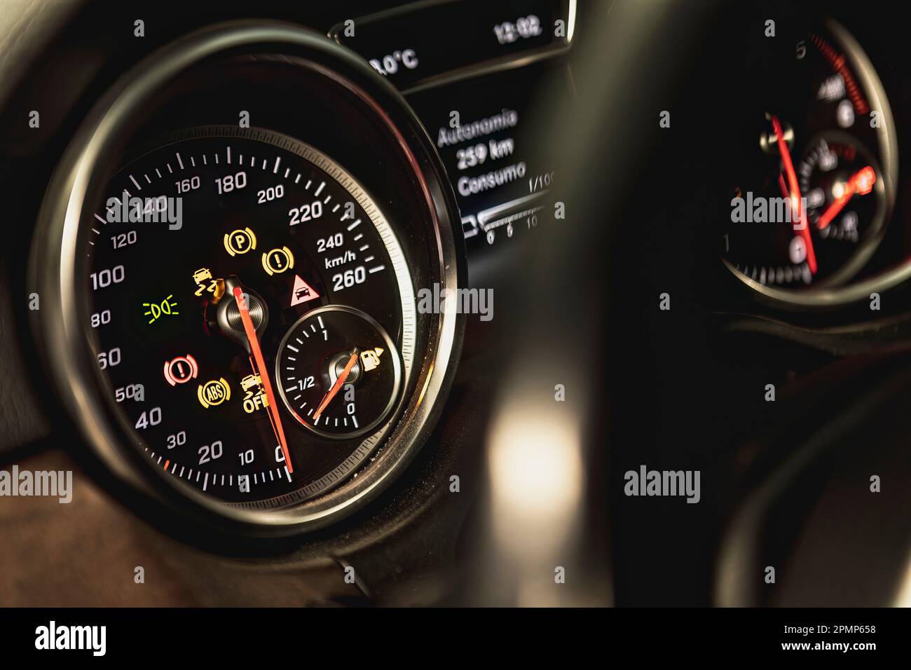 Closeup of a car dashboard with illuminated warning lights indicating