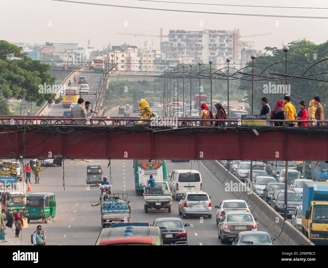 Traffic and a pedestrian bridge at a main road leading to downtown Dhaka, Bangladesh. Stock Photo