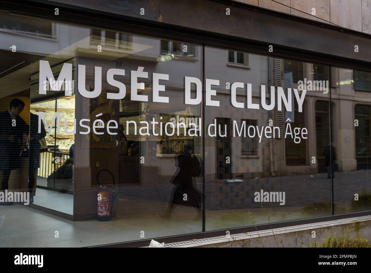 Musee De Cluny (Cluny Museum) text on the window with reflection from the street. Paris, France. March 24, 2023. Stock Photo