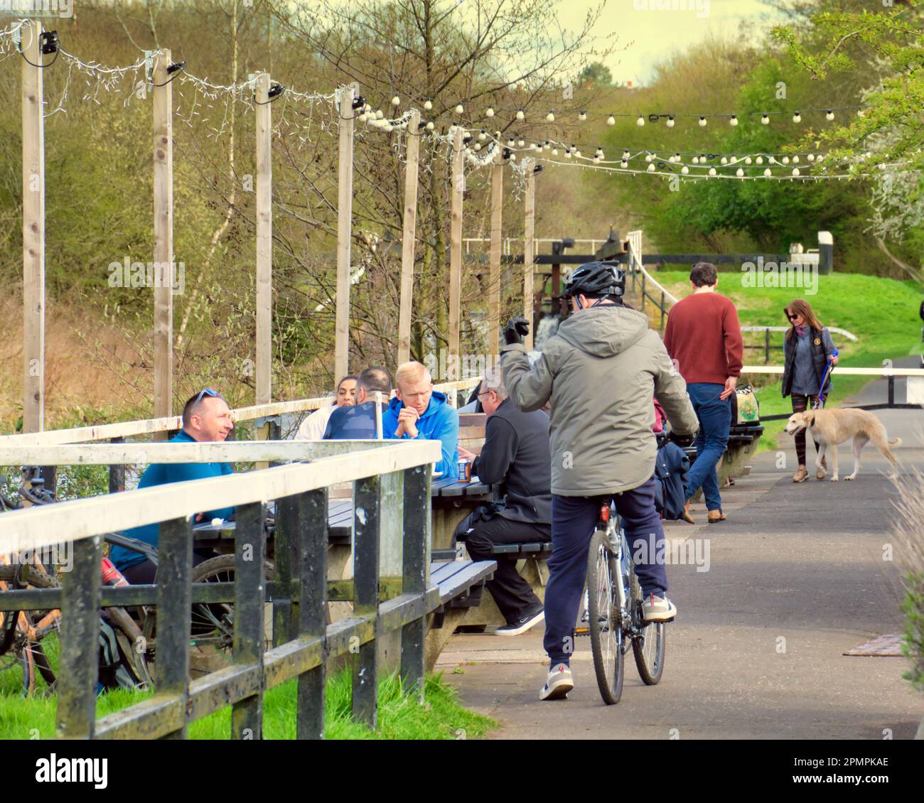 Glasgow, Scotland, UK 14th April, 2023. UK Weather: Sunshine saw people enjoy the forth and clyde canal at anniesland in the north west of the city in the dry weather walking about.Famous lock 27 pub and restaurant on the canal.  Credit Gerard Ferry/Alamy Live News Stock Photo
