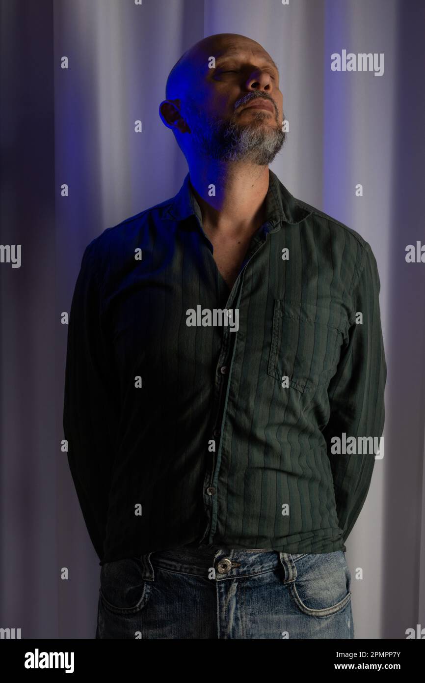 Standing, slim, serious and confident man. Studio portrait. white curtain background Stock Photo