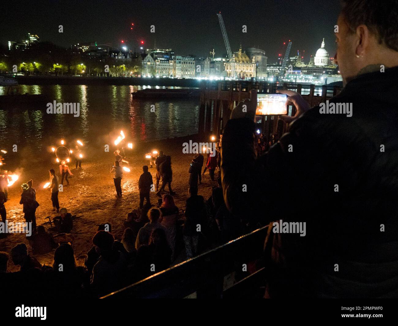 Fire jugglers and spectators on the south bank of River Thames at night