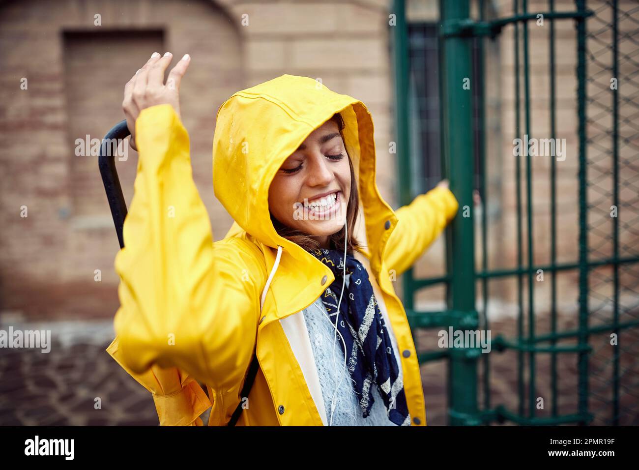 Cheerful girl in yellow raincoat enjoying outdoor Stock Photo Alamy