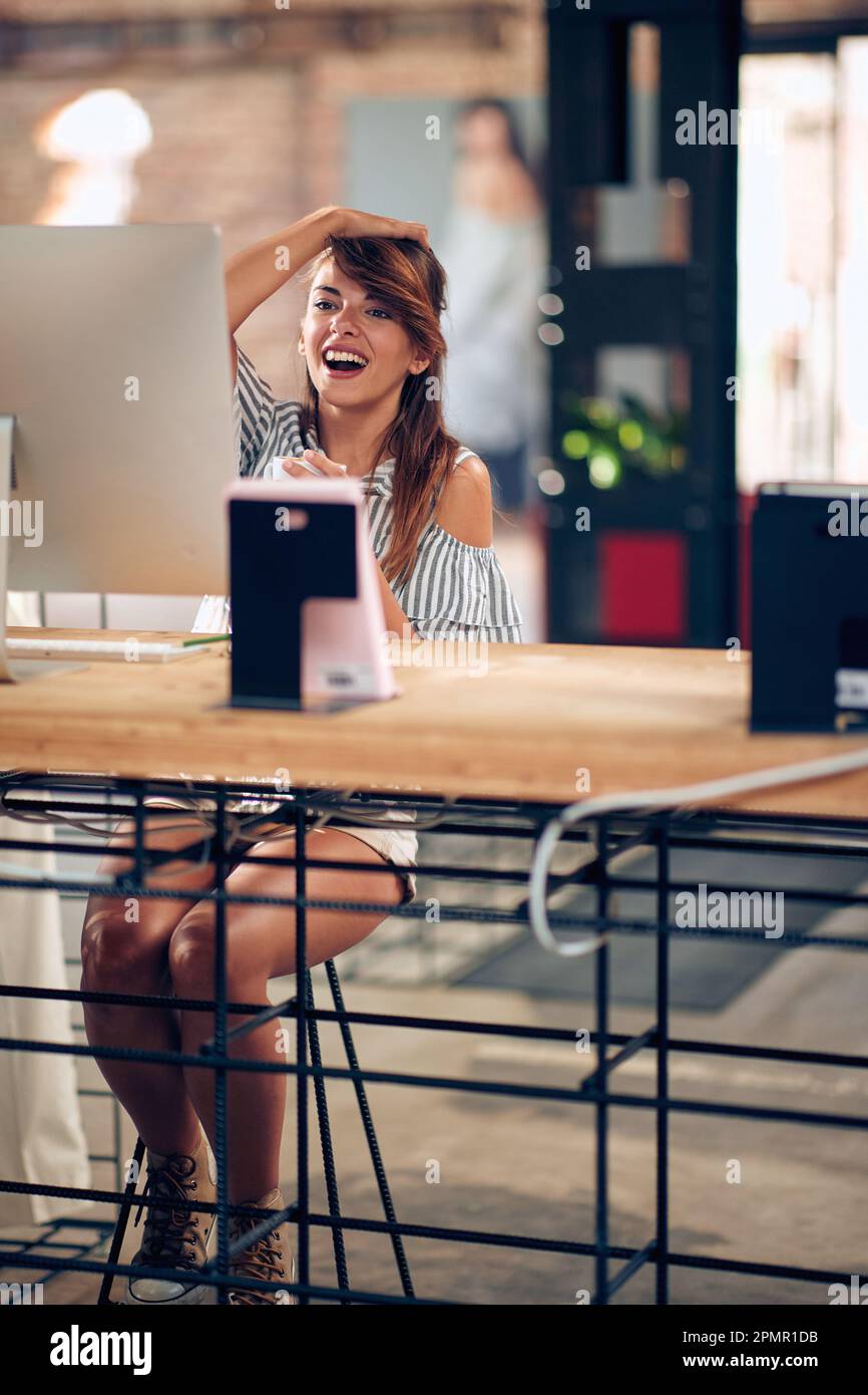 Young beautiful woman working on her computer and drinking coffee. Business, freelance, lifestyle concept. Stock Photo