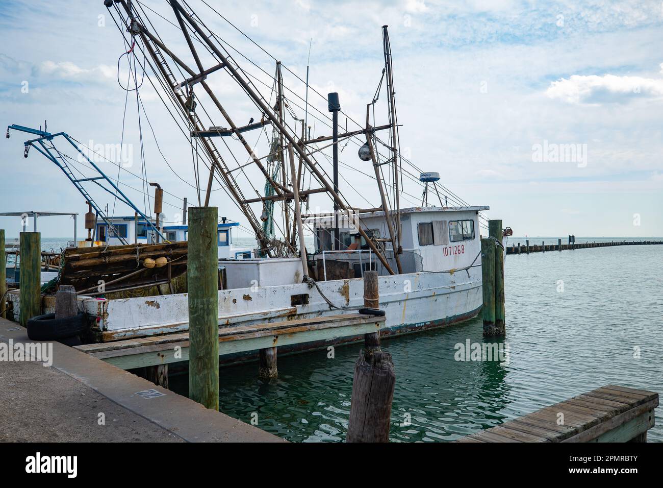 ROCKPORT, TX - 14 FEB 2023: Several commercial fishing boats, moored on the water at a dock in the marina at Rockport, Texas, on a mostly cloudy day. Stock Photo
