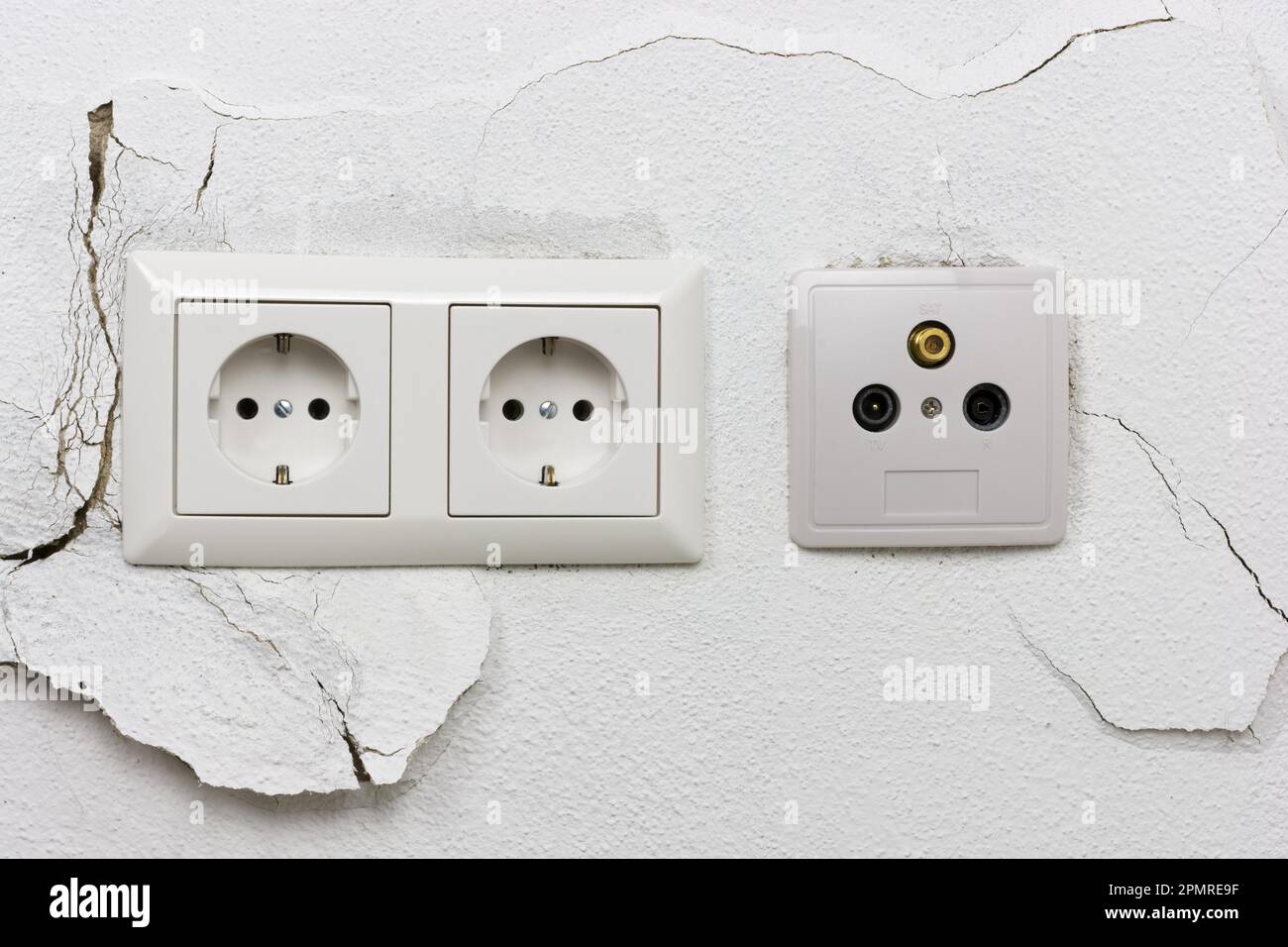 Wall plaster loosens around sockets Stock Photo