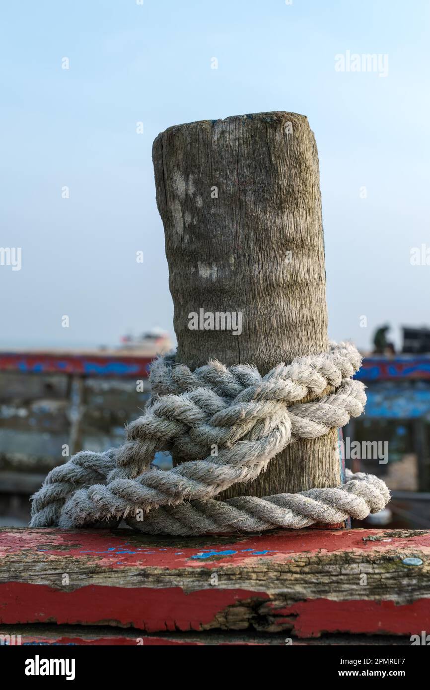 Rope coiled around a wooden post on a boat at Dungeness Stock Photo