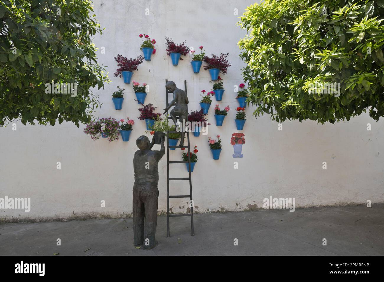 Bronze sculpture, child and grandfather tending potted plants, Cordoba, Andalusia, Spain Stock